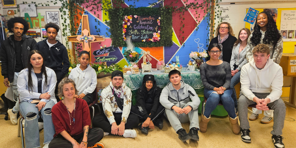 A group of students posing in front of an Easter presentation