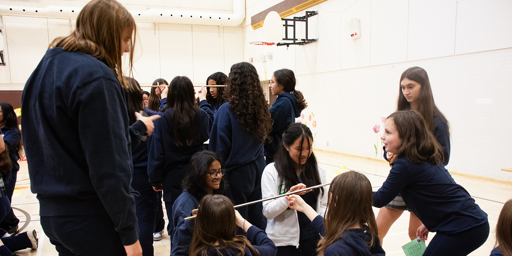 Photo of students doing science activities together in the school gym