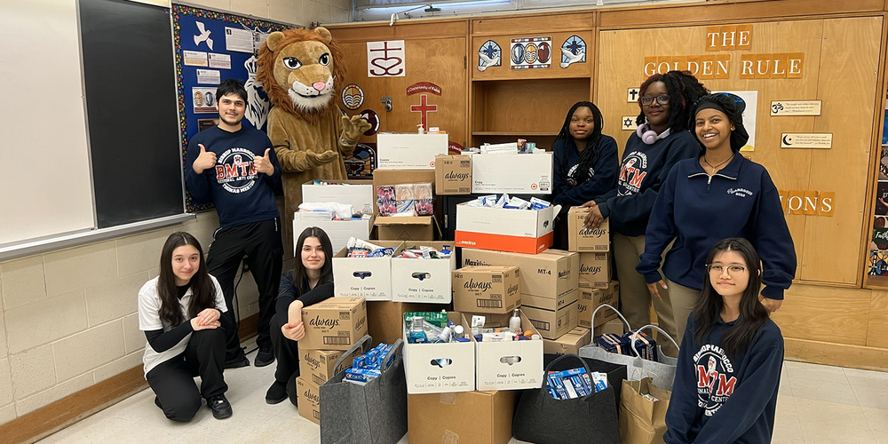 Photo of BMTM students with the boxes of donations that they collected