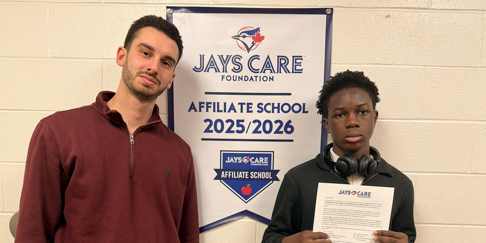 Photo of JCM staff member and student together with a banner behind them announcing the affiliation