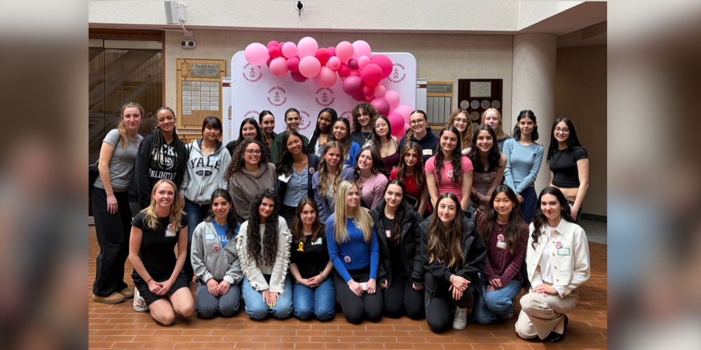 Large group of girls posing with pink balloons