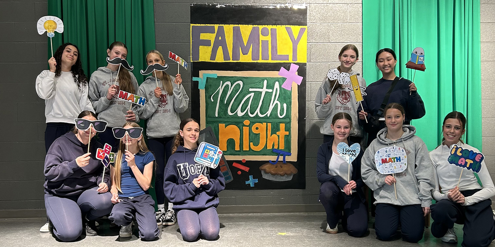 Photo of St. Ambrose students at Family Math Night with their props