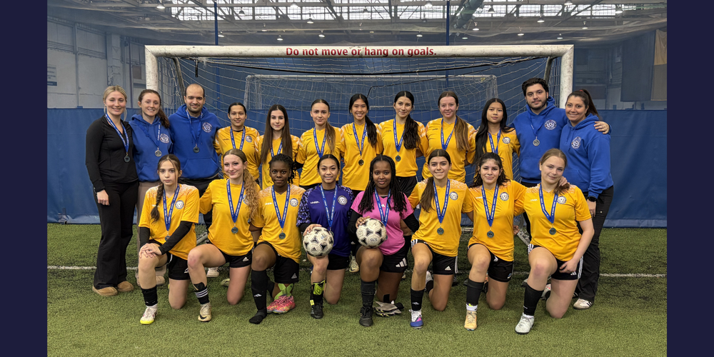 Soccer team posing on an indoor field