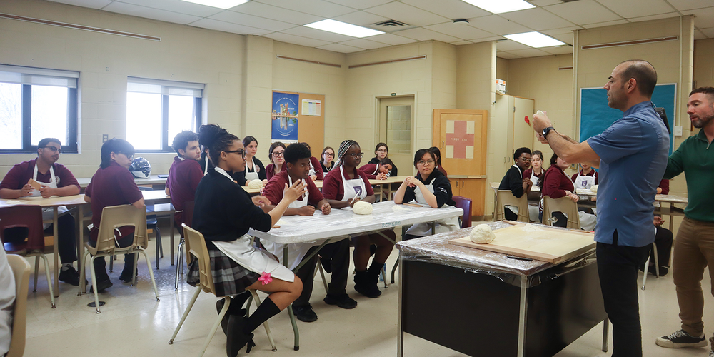St. OScar Romero students being coached by chef