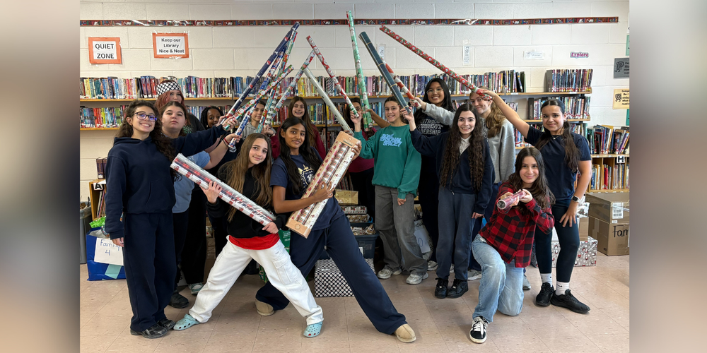 Group of students holding gift wrap rolls