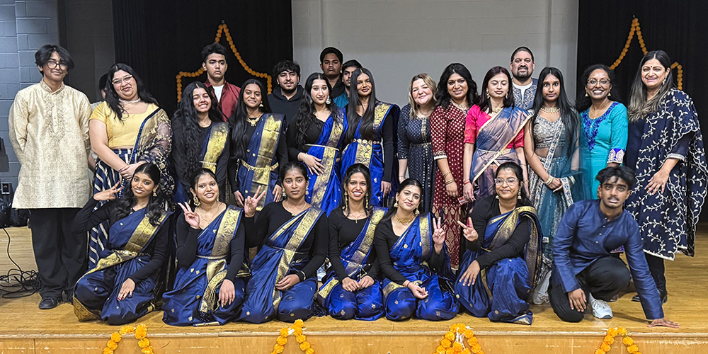 Group photo of performing students and adults in cultural clothing