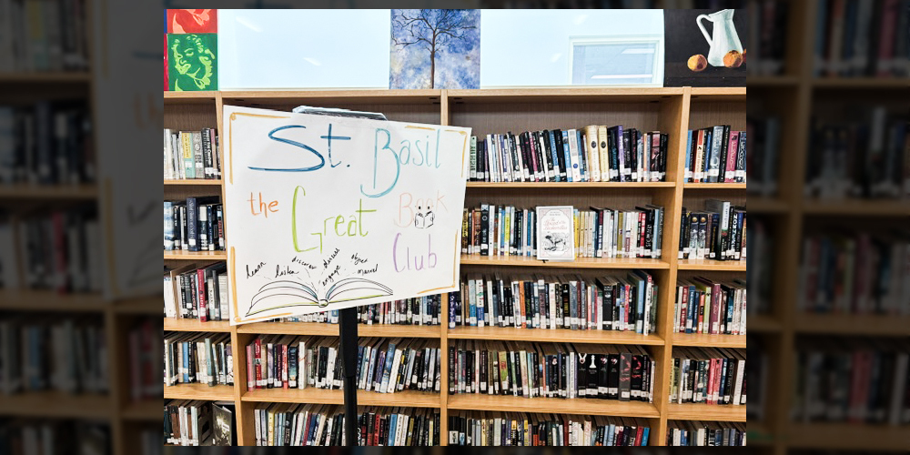 Photo of the St. Basil-the-Great library with the book club sign on a stand