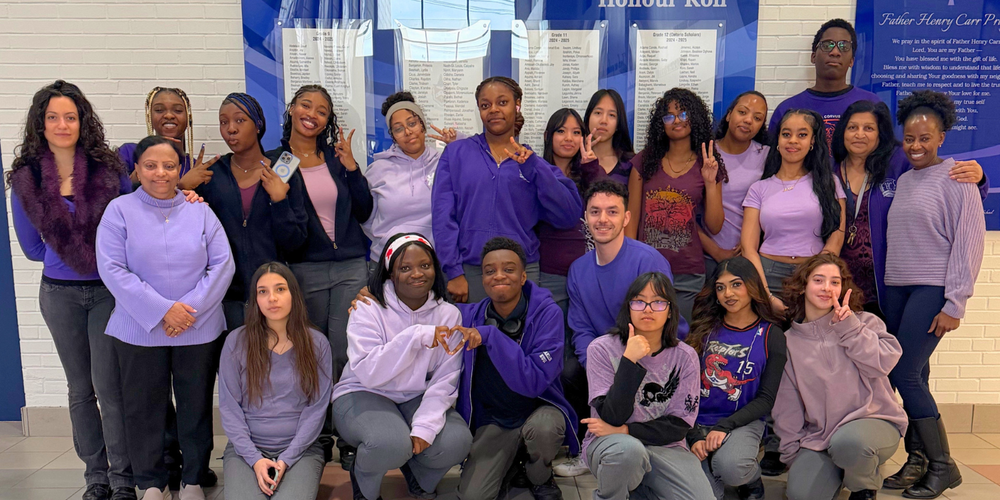 Group photo of students and faculty wearing purple.