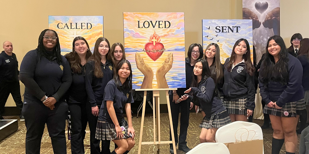 Students posing next to religious artwork