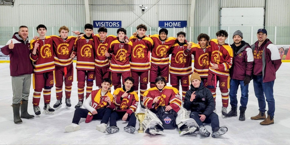 A hockey team posing in uniforms on the ice.