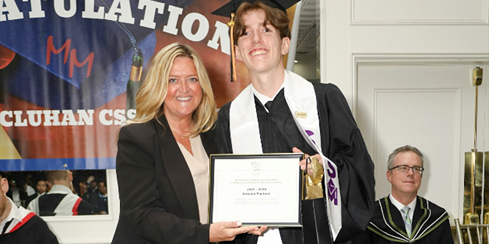 Photo of Antonio getting his framed certificate from Superintendent Shawna Campbell