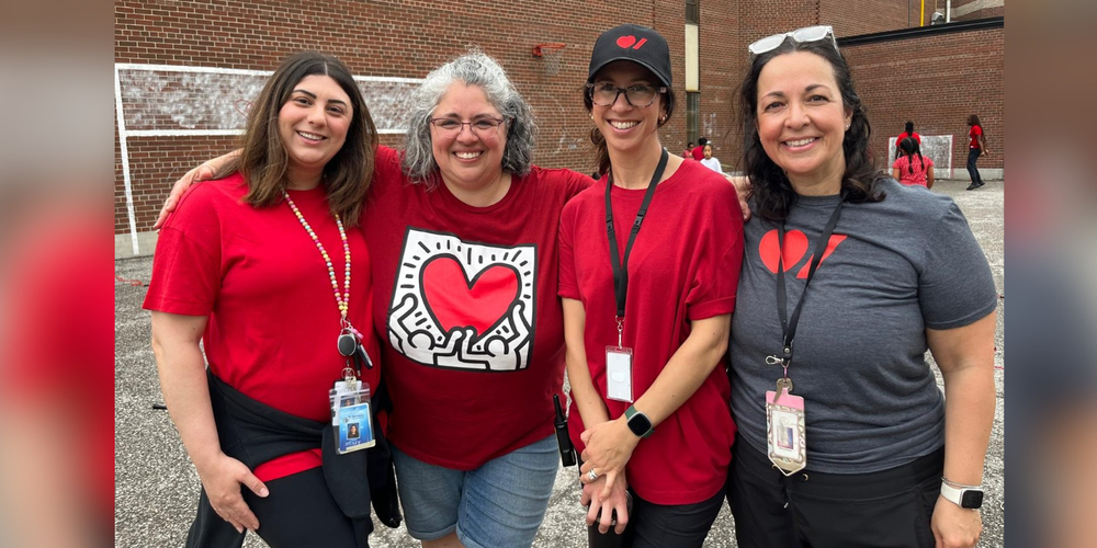 4 faculty posing with red/heart shirts