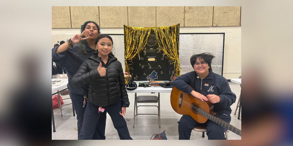3 students posing in front of Music Club Poster