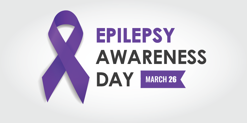 Purple awareness ribbon beside the words ‘Epilepsy Awareness Day’ with a banner reading ‘March 26’ on a light grey background.