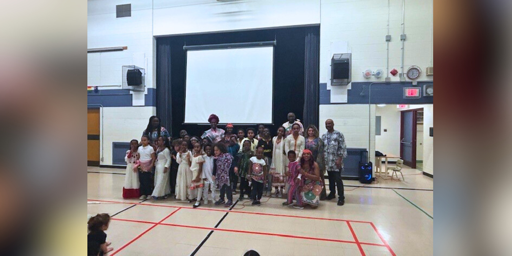 A group of children and faculty in a gym.