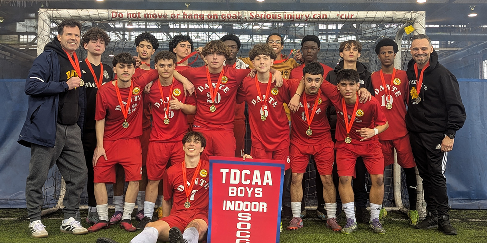 Group photo of Dante team in front of the net with their championship banner