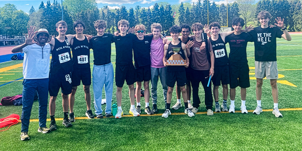 Group photo of Neil McNeil Catholic High School track and field team members celebrating winning their fifth Overall Boys Title in a row at the Metro championships held last week at Birchmount Stadium.