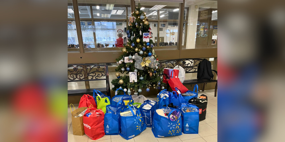 A Christmas tree with bags of gifts underneatah.