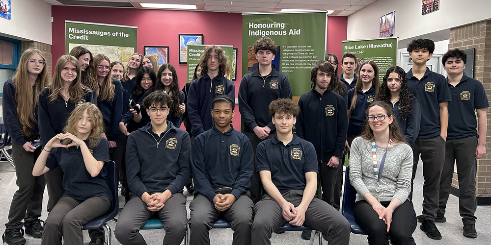 Group photo of Bishop Allen students and teacher with the exhibit