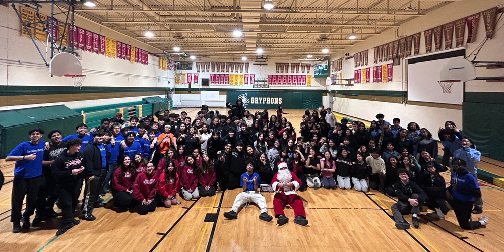 large group photo of students and santa in a gym