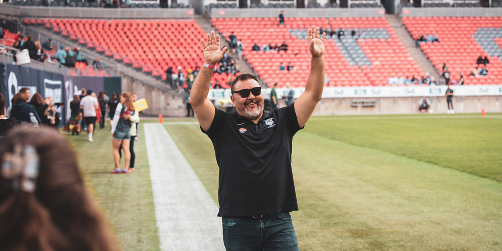 Photo of Coach Vescio on the field waving to people