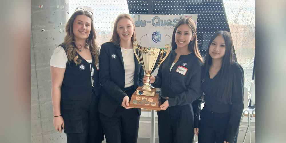 4 students holding an award. 