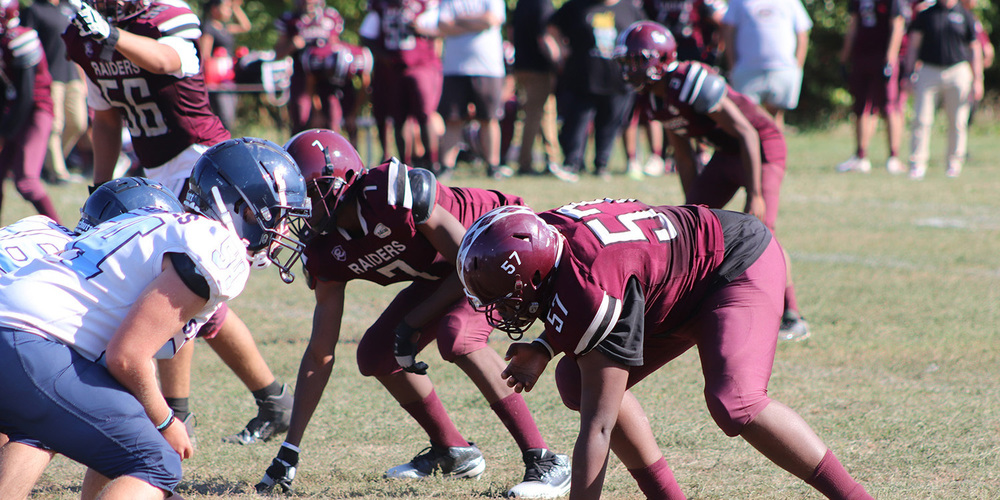 Photo of Romero and opposing team football players on the field during the game