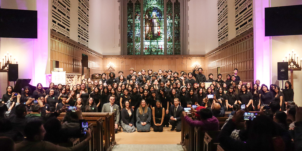 Group photo of the Senator O'Connor, SJMP and Marshall McLuhan choirs together in Timothy Eaton Memorial Church with audience members in the pew