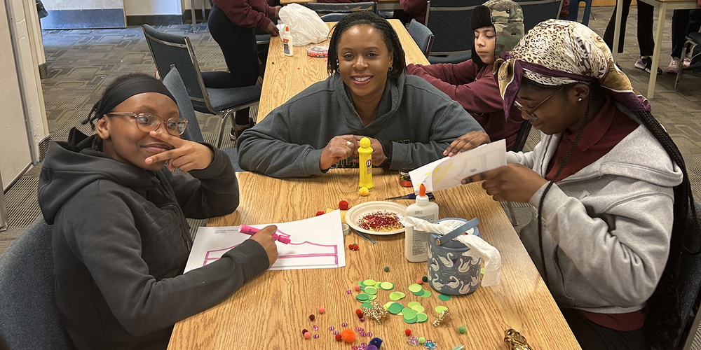 Photo of three students designing their crown decorations together