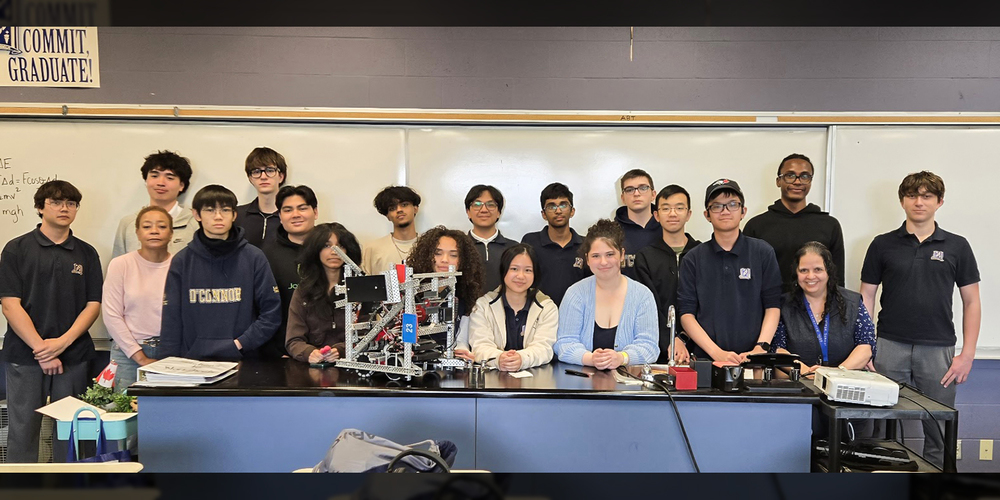Photo of the OCS Robotics team staff and students with the robot they built
