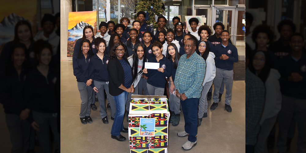 Group photo of Redmond students and The Jamaican Canadian Society representatives with the boxes of food and supplies collected and the cheque