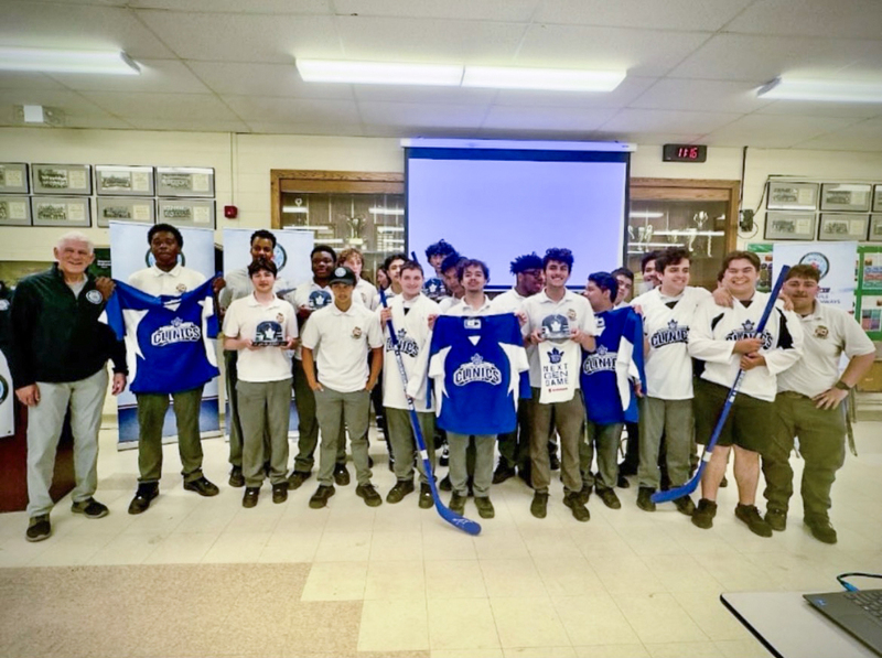 Photo of Chaminade students holding up new hockey shirts and equipment