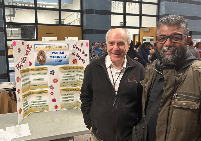 Photo of community members presenting at Our Lady of Lourdes to families during the event