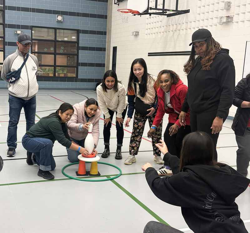 Photo of students, staff, and community members enjoying games in the school gym