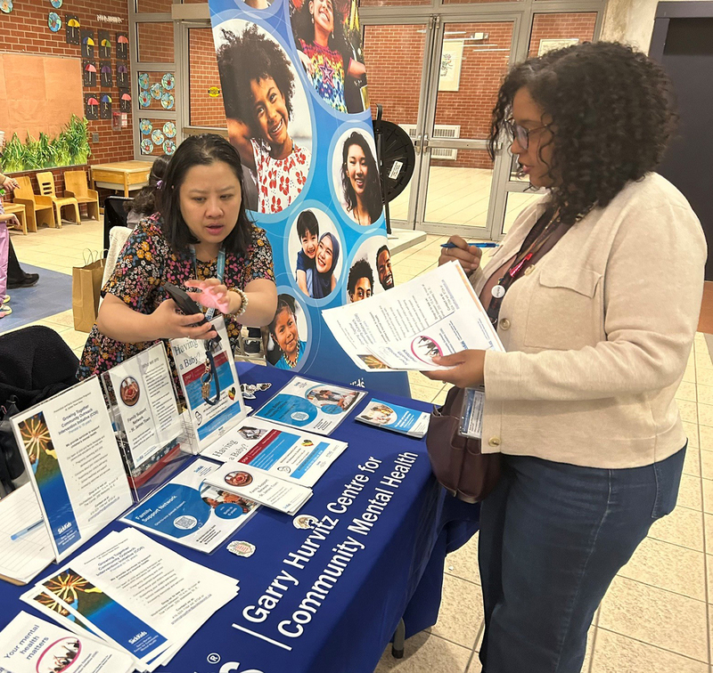 Photo of community members presenting at Our Lady of Lourdes to families during the event