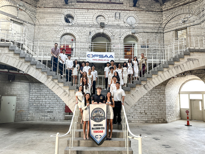 Group photo of the Rebels team with their championship banner