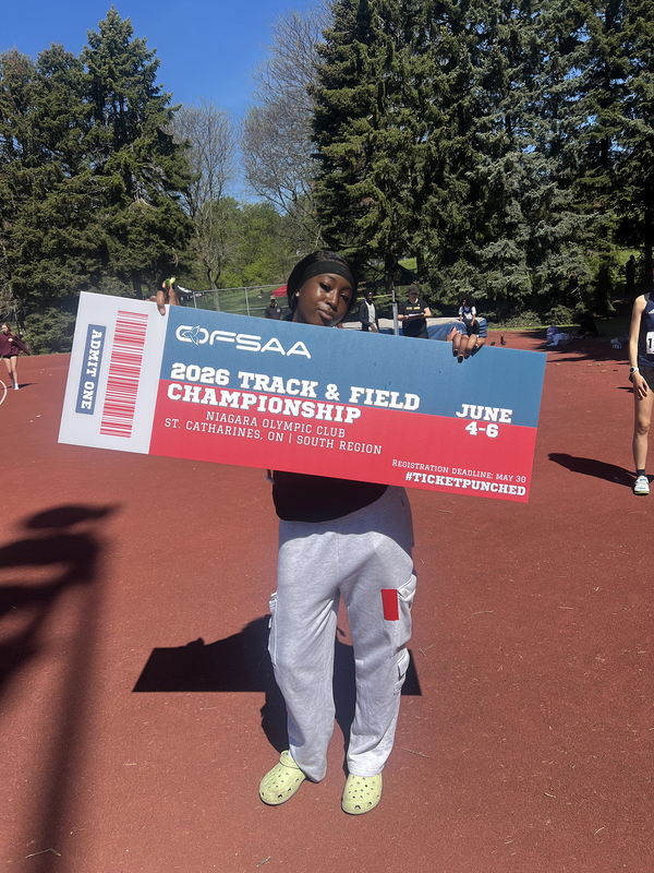 Photo of JCM athlete on the field holding up OFSAA ticket
