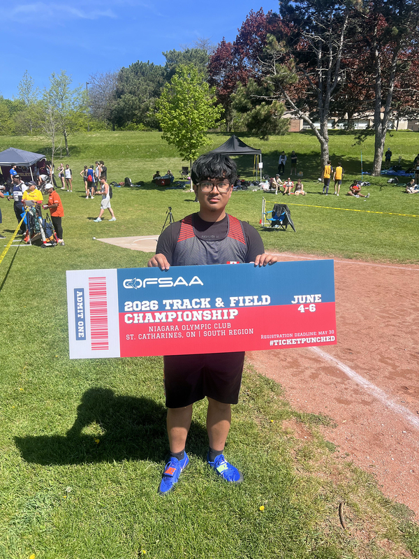 Photo of JCM athlete on the field holding up OFSAA ticket