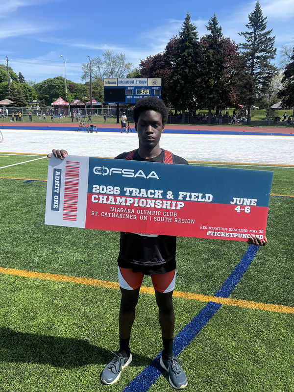 Photo of JCM athlete on the field holding up OFSAA ticket