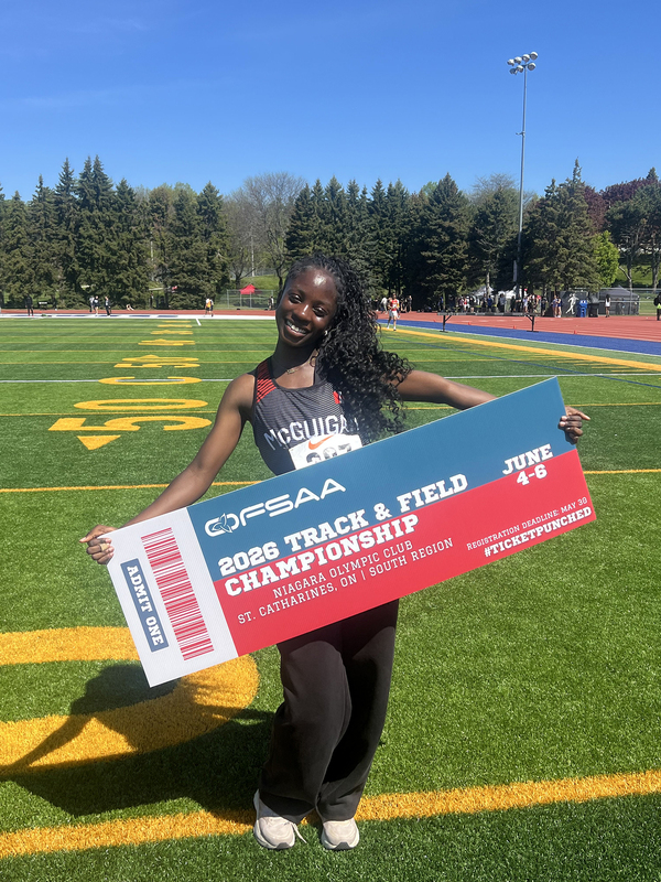 Photo of JCM athlete on the field holding up OFSAA ticket