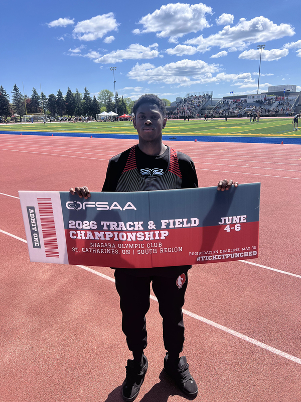 Photo of JCM athlete on the field holding up OFSAA ticket
