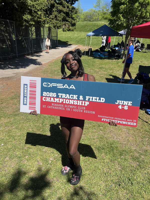 Photo of JCM athlete on the field holding up OFSAA ticket