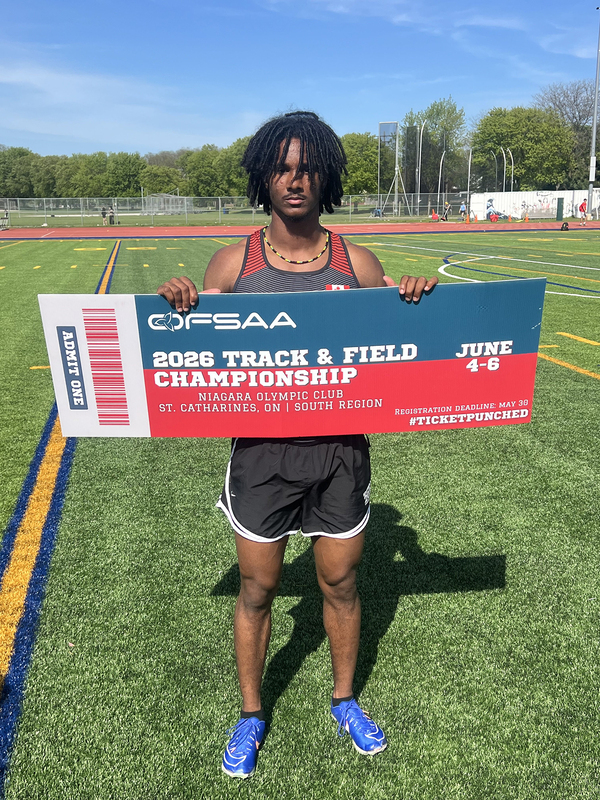 Photo of JCM athlete on the field holding up OFSAA ticket