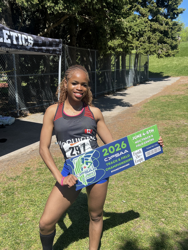 Photo of JCM athlete on the field holding up OFSAA ticket