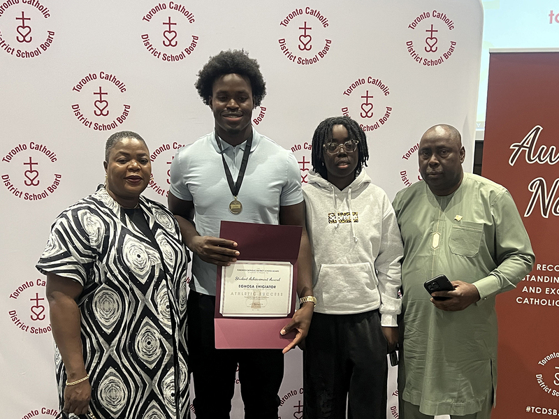 Photo of JCM athlete with award plaque and family