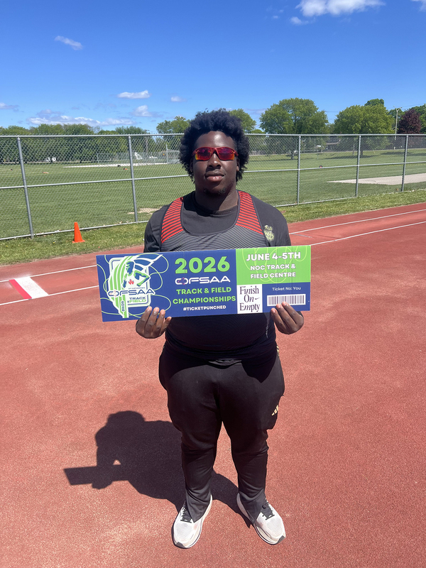 Photo of JCM athlete on the field holding up OFSAA ticket
