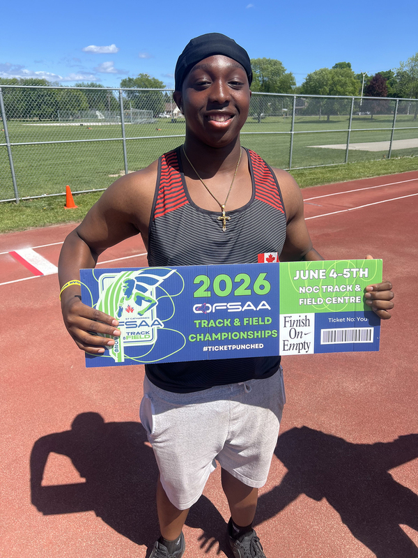 Photo of JCM athlete on the field holding up OFSAA ticket