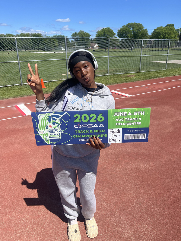 Photo of JCM athlete on the field holding up OFSAA ticket
