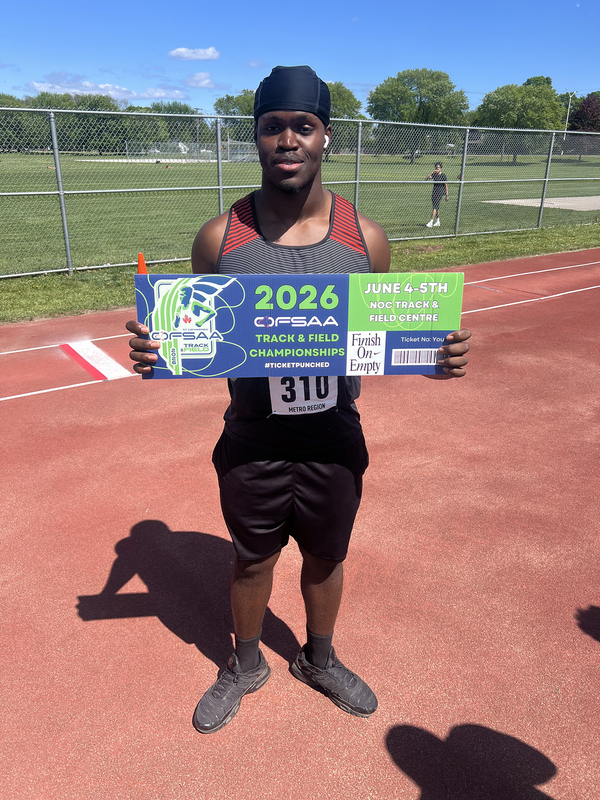 Photo of JCM athlete on the field holding up OFSAA ticket
