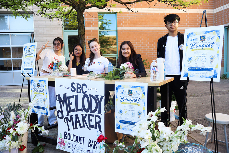 Photo of students running the flower boquet bar at the showcase